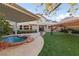 Charming backyard featuring a cozy pool, covered patio, and lush green lawn at 7438 Desertscape Ave, Las Vegas, NV 89178