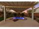 Backyard oasis with a rock waterfall feature and relaxing covered patio with string lights at 7438 Desertscape Ave, Las Vegas, NV 89178