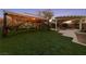 Manicured backyard featuring an outdoor gazebo with lights and landscaping at 7438 Desertscape Ave, Las Vegas, NV 89178