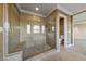 Shower with neutral tile surround, glass doors, and built-in bench seating at 7438 Desertscape Ave, Las Vegas, NV 89178