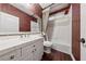 Bathroom with white vanity, white tile tub and shower with glass doors and decorative wallpaper at 7438 Desertscape Ave, Las Vegas, NV 89178