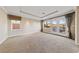 Spacious bedroom with plush carpeting, tray ceiling, balcony, and large windows for natural light at 7438 Desertscape Ave, Las Vegas, NV 89178