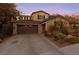 Inviting two-story home featuring a spacious driveway and a well-manicured desert landscape at 7438 Desertscape Ave, Las Vegas, NV 89178