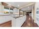 Kitchen with large island, stainless appliances, white cabinets, granite countertops and hardwood floors at 7438 Desertscape Ave, Las Vegas, NV 89178
