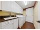 Well-organized laundry room with white cabinetry, sink, washer, and dryer at 7438 Desertscape Ave, Las Vegas, NV 89178