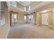 Bright, open living room with high ceilings, large windows, and neutral carpet at 7438 Desertscape Ave, Las Vegas, NV 89178