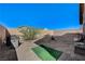 Large backyard with gravel, accented by a cozy seating area and secure perimeter fencing for privacy at 76 Summer Rhapsody Ave, Henderson, NV 89015