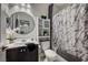 Cozy bathroom featuring a vanity with sink, round mirror, toilet, and shower with decorative marble-style curtain at 76 Summer Rhapsody Ave, Henderson, NV 89015