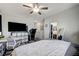 Open main bedroom featuring a ceiling fan, carpeted floor, and an access to the bathroom at 76 Summer Rhapsody Ave, Henderson, NV 89015