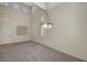Spacious living room with high ceilings, carpet, and contemporary chandelier lighting at 8040 Tailwind Ave, Las Vegas, NV 89131