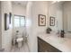 Chic powder room with modern fixtures, framed butterfly art, and a sleek vanity, designed for both style and convenience at 8092 Haywood Estate Ave, Las Vegas, NV 89113