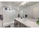 Modern bathroom featuring marble countertop, sleek cabinets, large mirror, and glass-enclosed shower at 8092 Haywood Estate Ave, Las Vegas, NV 89113