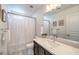 Well-lit bathroom showcasing a modern vanity, framed mirror, and shower with decorative curtain at 8092 Haywood Estate Ave, Las Vegas, NV 89113