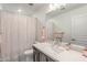 This bathroom features a modern vanity with a white countertop, and a shower curtain with gold stripes at 8092 Haywood Estate Ave, Las Vegas, NV 89113