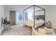 Brightly lit bedroom with canopy bed, a side-chair, large window with white curtains at 8092 Haywood Estate Ave, Las Vegas, NV 89113