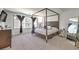 Tranquil bedroom featuring a four-poster bed, neutral colors, and large windows offering serene views and ample natural light at 8092 Haywood Estate Ave, Las Vegas, NV 89113