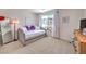 Bright bedroom featuring a daybed with decorative pillows, side table, and large window at 8092 Haywood Estate Ave, Las Vegas, NV 89113