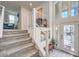 Bright entryway featuring a modern staircase with white railings and natural light from the front door and transom windows at 8092 Haywood Estate Ave, Las Vegas, NV 89113