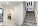 Modern entryway with tiled floors, staircase to the right, and a partial view of the downstairs bathroom at 8092 Haywood Estate Ave, Las Vegas, NV 89113