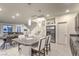Open-concept kitchen and dining area with granite counters, stainless appliances, and adjacent staircase and living room at 8092 Haywood Estate Ave, Las Vegas, NV 89113