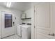 Bright laundry room with white front-loading washer and dryer, a door to the outside and a decorative sign at 8092 Haywood Estate Ave, Las Vegas, NV 89113