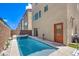 A stylish backyard featuring a modern pool, spa, door to the house, and privacy wall at 8092 Haywood Estate Ave, Las Vegas, NV 89113