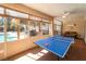 A sunroom with ping pong table, tropical decor and backyard pool views at 8125 Soledad Canyon St, Las Vegas, NV 89131