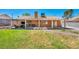 A spacious backyard featuring a covered patio, a green lawn, and a brick pathway, perfect for relaxation and entertainment at 819 Arrowhead Trl, Henderson, NV 89002