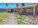 A backyard showcases a covered patio, a verdant lawn, and a brick pathway, creating an inviting outdoor retreat at 819 Arrowhead Trl, Henderson, NV 89002