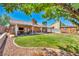 A lush backyard with a covered patio, a manicured lawn, and gravel landscaping, great for Gathering gatherings and relaxation at 819 Arrowhead Trl, Henderson, NV 89002