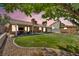 A verdant backyard with a covered patio, a manicured lawn, and gravel landscaping under a vibrant twilight sky at 819 Arrowhead Trl, Henderson, NV 89002