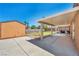A spacious backyard featuring a covered patio area, a shed, and a well-maintained lawn, ideal for outdoor activities at 819 Arrowhead Trl, Henderson, NV 89002
