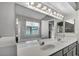 Bright bathroom featuring double sinks, a glass shower, and a large vanity mirror at 819 Arrowhead Trl, Henderson, NV 89002