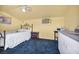 This bedroom offers a serene retreat with light yellow walls, blue carpet, kitchenette, and a comfortable queen bed at 819 Arrowhead Trl, Henderson, NV 89002