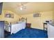 This bedroom offers a serene retreat with light yellow walls, blue carpet, kitchenette, and a comfortable queen bed at 819 Arrowhead Trl, Henderson, NV 89002