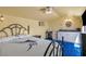 Cozy bedroom featuring light yellow walls, blue carpeting, kitchenette area and a queen-sized bed at 819 Arrowhead Trl, Henderson, NV 89002