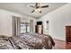 Bedroom featuring a bed, ceiling fan, dresser and backyard views at 819 Arrowhead Trl, Henderson, NV 89002