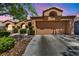 Beautiful single-story home features a two-car garage and desert landscaping with mature shrubs at 819 Arrowhead Trl, Henderson, NV 89002
