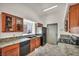 Well-lit kitchen featuring ample counter space, sleek black appliances, and wooden cabinets for storage at 819 Arrowhead Trl, Henderson, NV 89002