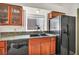 Kitchen with black appliances, wood cabinetry, and a stainless steel sink with a view to the backyard at 819 Arrowhead Trl, Henderson, NV 89002