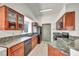 Well-lit kitchen featuring ample counter space, sleek black appliances, and wooden cabinets for storage at 819 Arrowhead Trl, Henderson, NV 89002