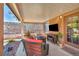 Inviting covered patio with comfortable seating, a tv, and a view of the backyard at 819 Arrowhead Trl, Henderson, NV 89002