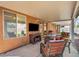 A covered patio featuring cozy wicker furniture, a TV, and a grill, perfect for outdoor relaxation and entertainment at 819 Arrowhead Trl, Henderson, NV 89002