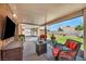 Cozy covered patio with comfortable seating and a view of the lush backyard at 819 Arrowhead Trl, Henderson, NV 89002