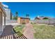 A backyard featuring a storage shed, a small bench, a grassy area, and rock landscaping, offering practicality and charm at 819 Arrowhead Trl, Henderson, NV 89002