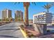 Community entrance sign with palm trees and lush landscaping under a clear blue sky at 8255 One Las Vegas Blvd # 504, Las Vegas, NV 89123