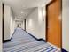 Long hallway featuring a blue striped carpet, white walls, and wooden doors at 8255 One Las Vegas Blvd # 504, Las Vegas, NV 89123