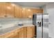 Well-lit kitchen featuring light wood cabinets, granite countertops, and stainless steel refrigerator at 8255 One Las Vegas Blvd # 504, Las Vegas, NV 89123