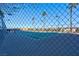 Brightly lit tennis court featuring palm trees behind a chain-link fence on a sunny day at 8255 One Las Vegas Blvd # 504, Las Vegas, NV 89123