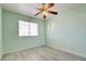Serene bedroom featuring wood-look flooring, a ceiling fan, and a window dressed with blinds for optimal privacy at 8370 Lost Lake Ct, Las Vegas, NV 89147